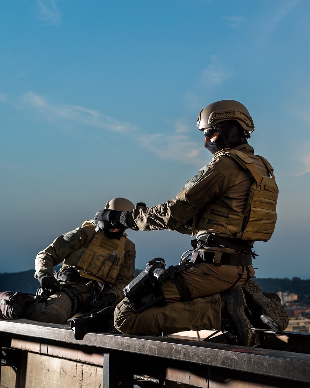 Two soldiers gearing up on a roof